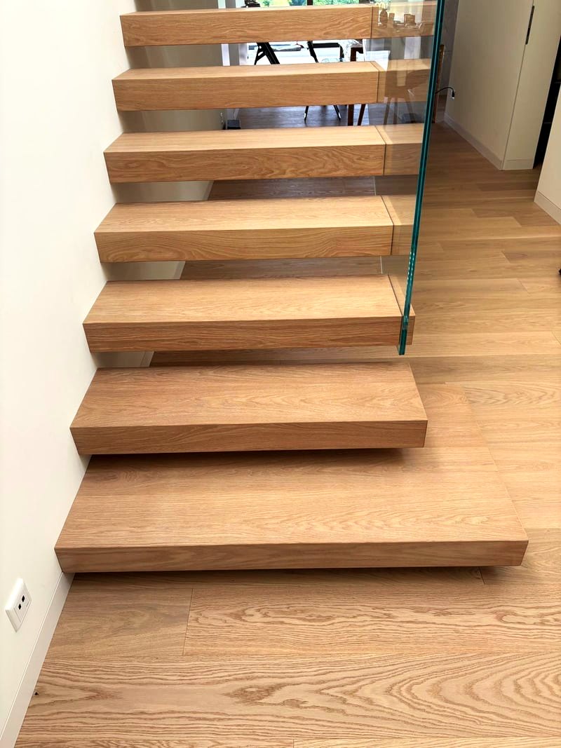 Antritt der Kragarmtreppe: Eichenstufen frei aus der Wand, rechts das Klarglasgeländer